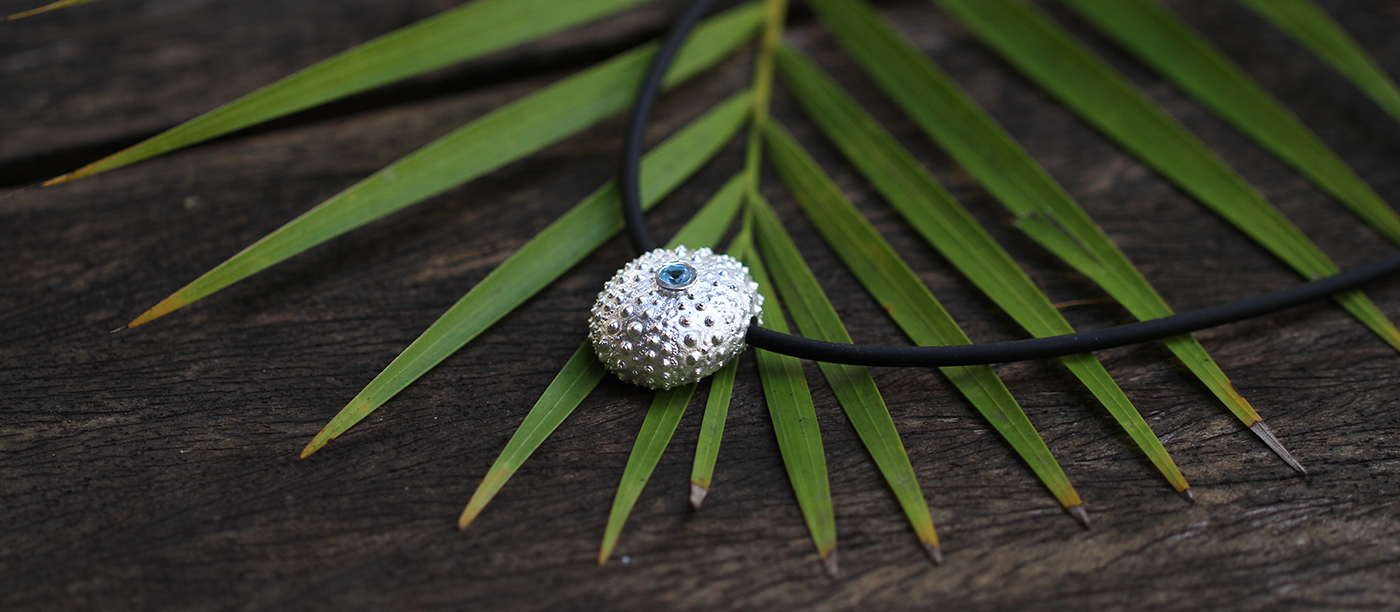 Complete sea urchin pendant in sterling silver with a Blue Topas sitting at its center,