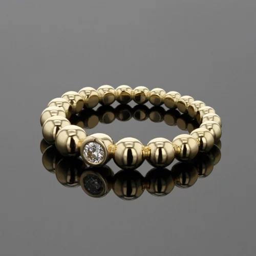 Yellow gold ring made up of balls with a center diamond