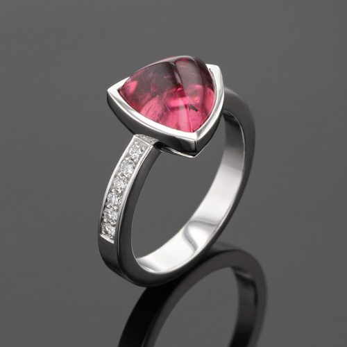 White gold ring with diamonds on the shank and a trillion shaped Pink Tourmaline