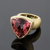 Statement ring in brushed yellow gold with a large trillion shaped Pink Tourmaline