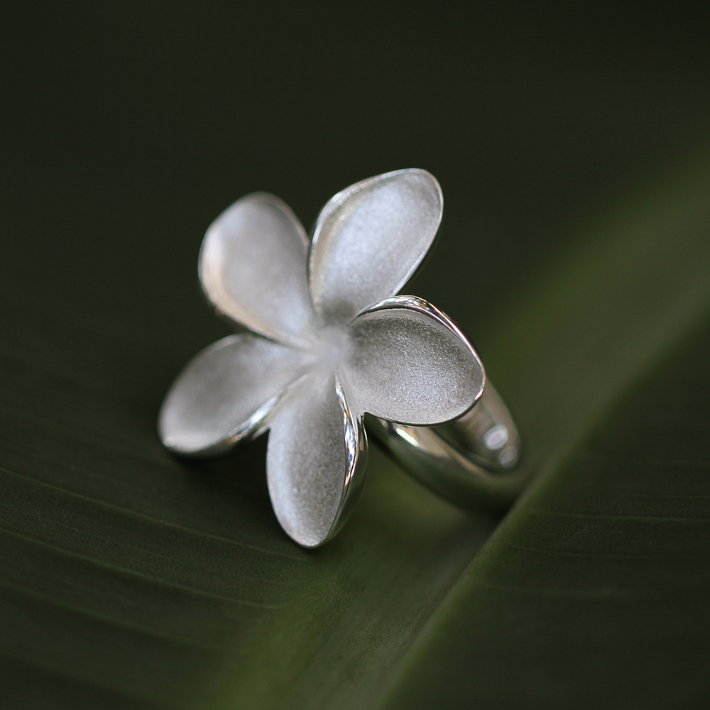 Polished silver band with a frangipani flower in a matted finish as a head