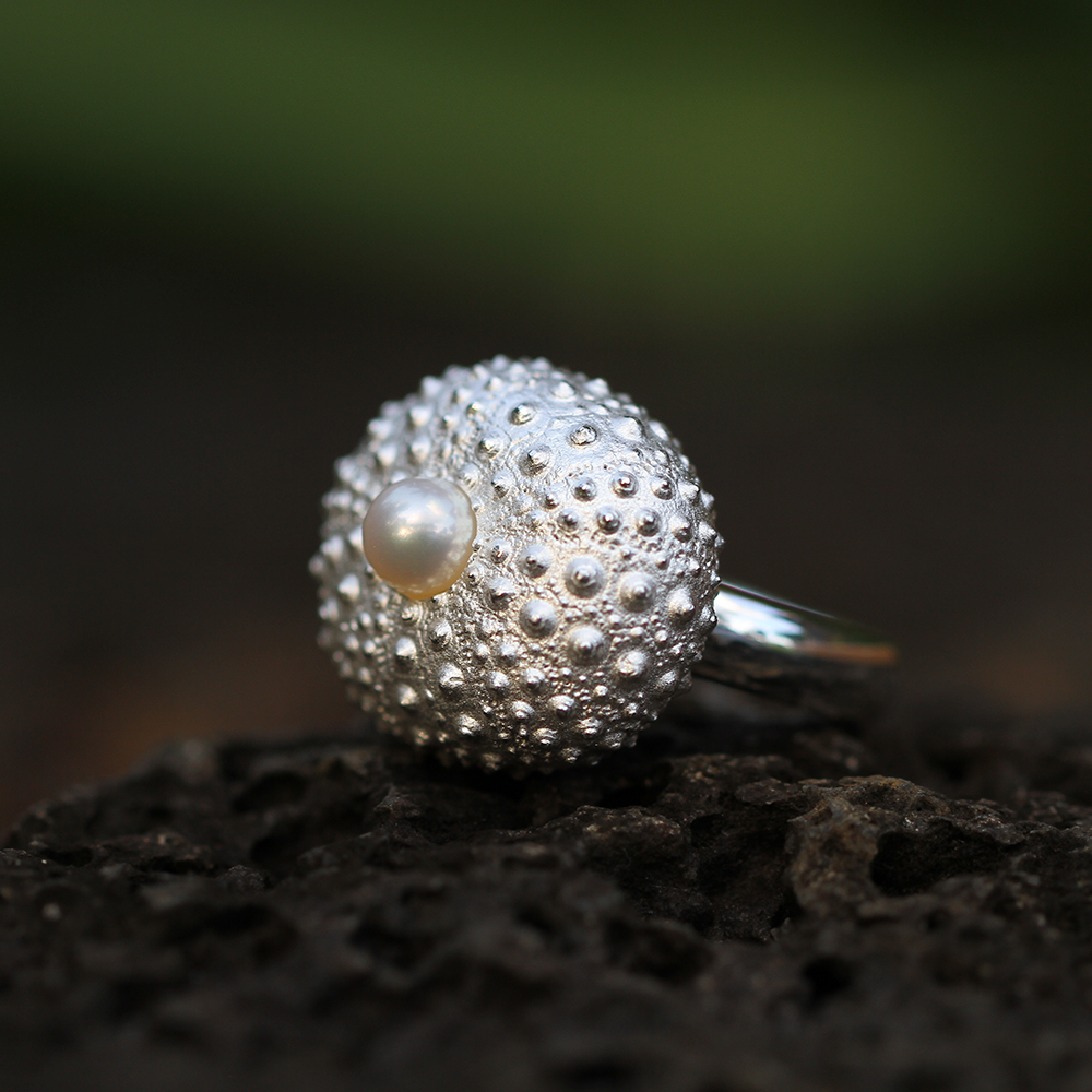 Statement ring in silver with a large sea urchin head and freshwater pearl at its center.