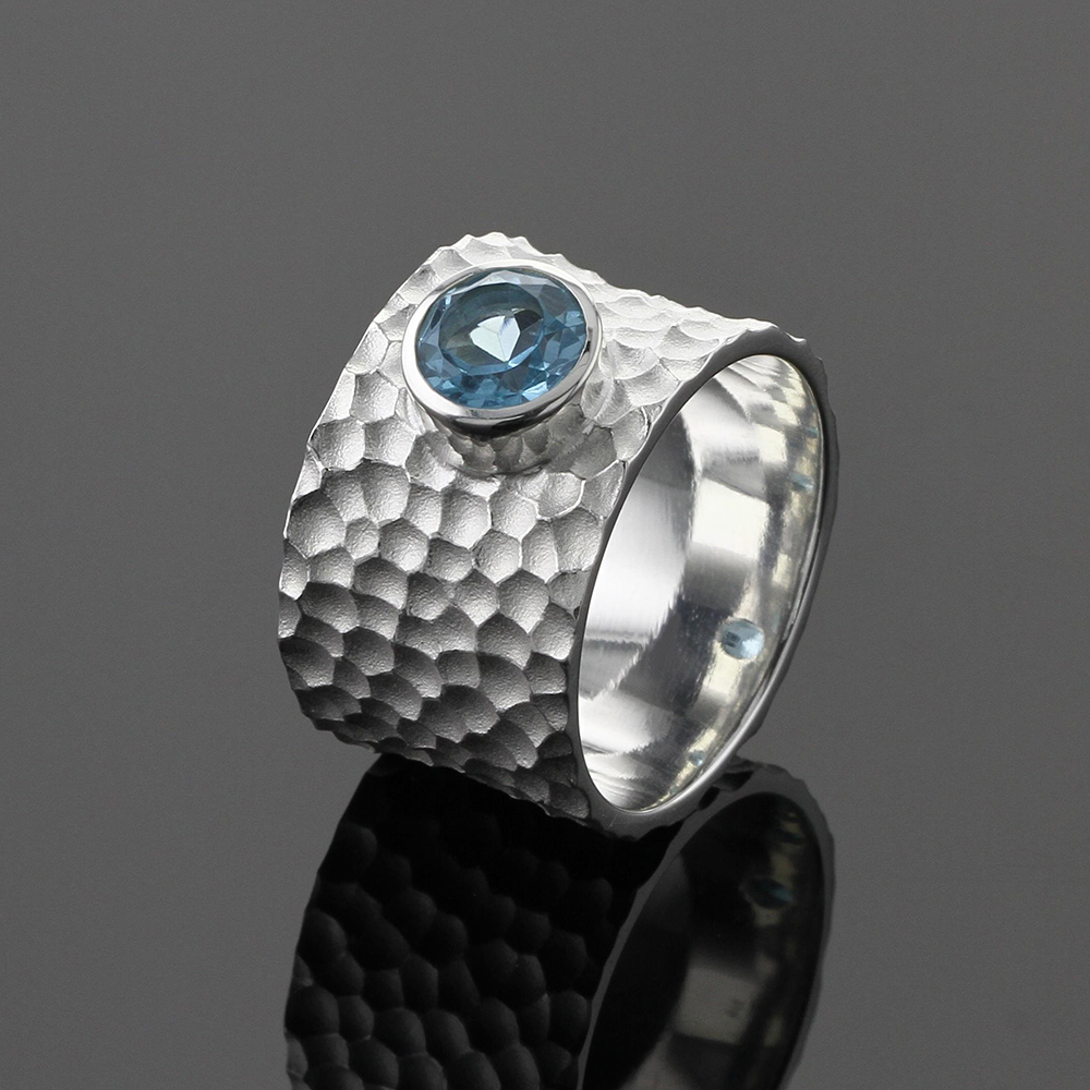 Wide silver ring with lava texture and Blue Topas