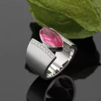 Wide ring in matted white gold with a marquise shaped pink center stone and diamonds