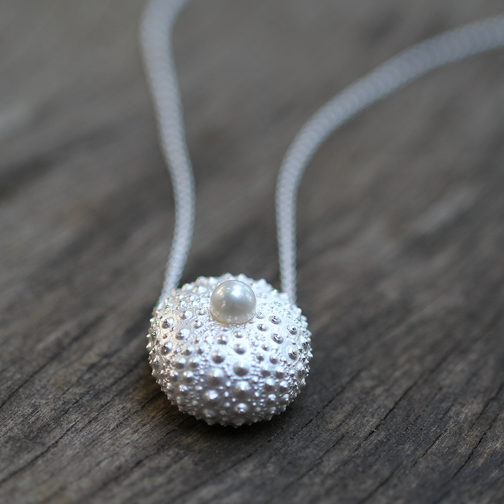 Large sea urchin pendant in sterling silver with a freshwater pearl sitting at its center