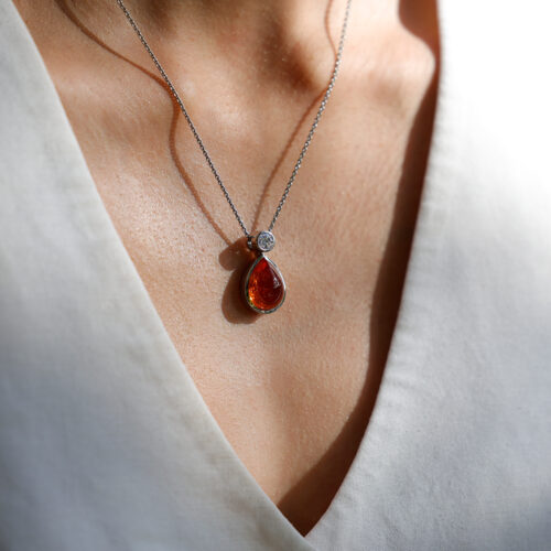 Drop shaped Mandarin Garnet set in 18ct white gold pendant with a 0.55ct diamond