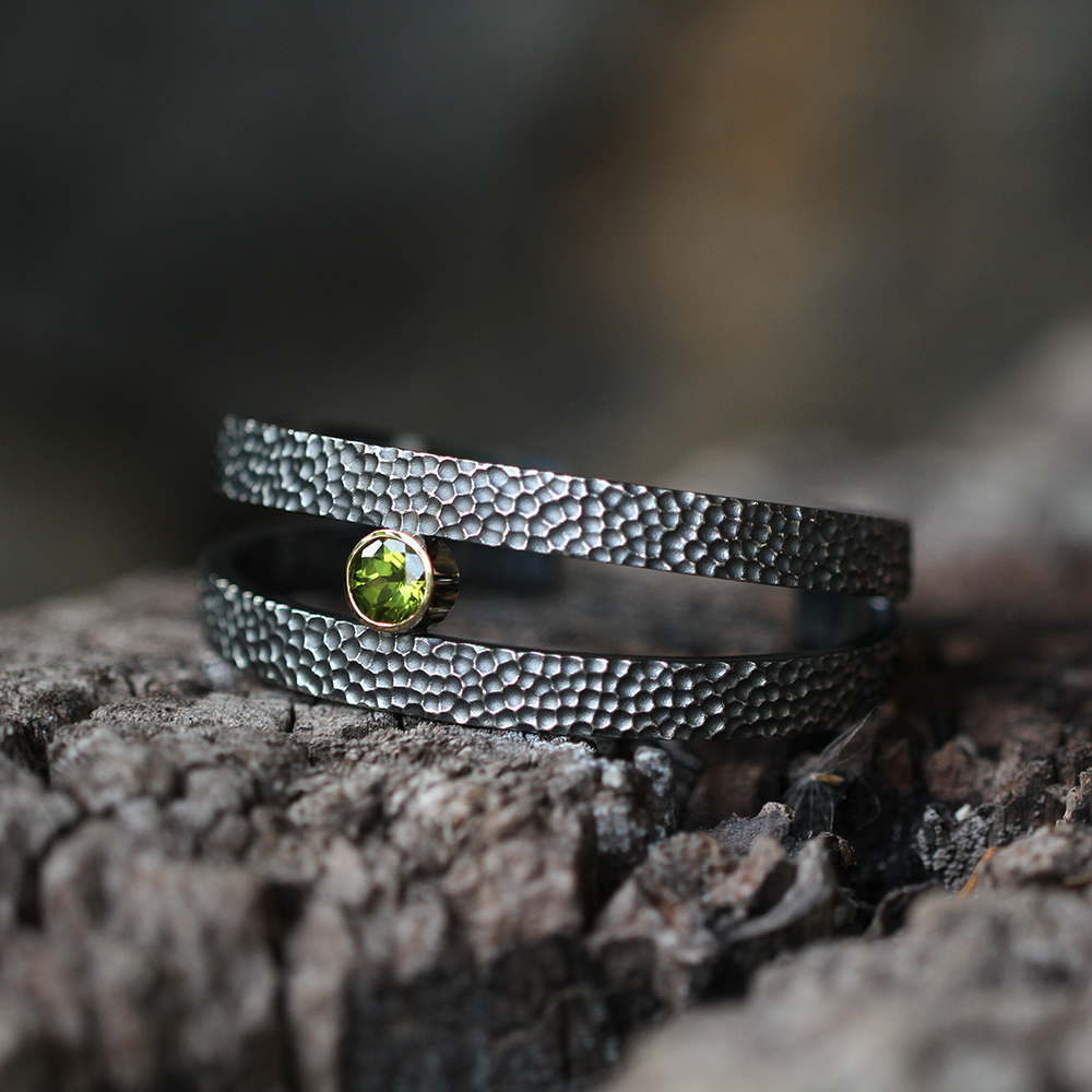 Bangle in black silver with a rock texture and Peridot stone.