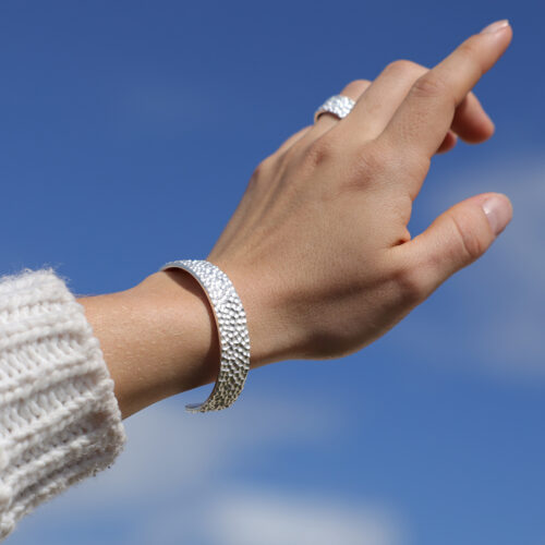 Wide bangle in silver with a rock texture