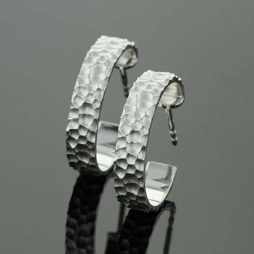 Silver hoop earrings with a lava rock texture
