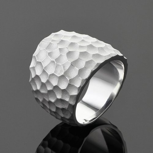 Wide silver ring with a rock inspired texture.