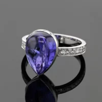 18ct white gold ring with diamonds on its shank and a large tear dropped Tanzanite cabochon