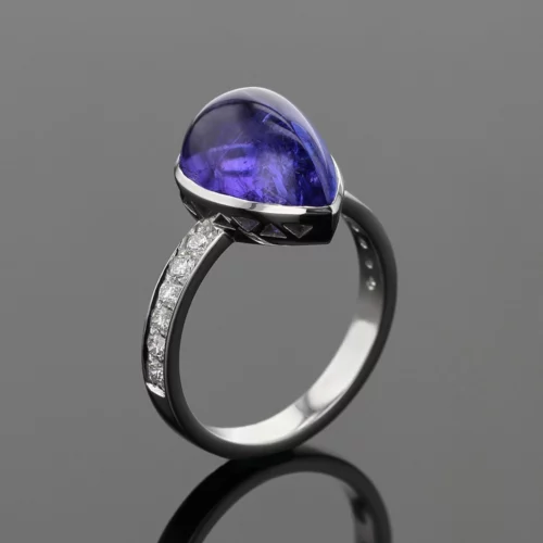 18ct white gold ring with diamonds on its shank and a large tear dropped Tanzanite cabochon