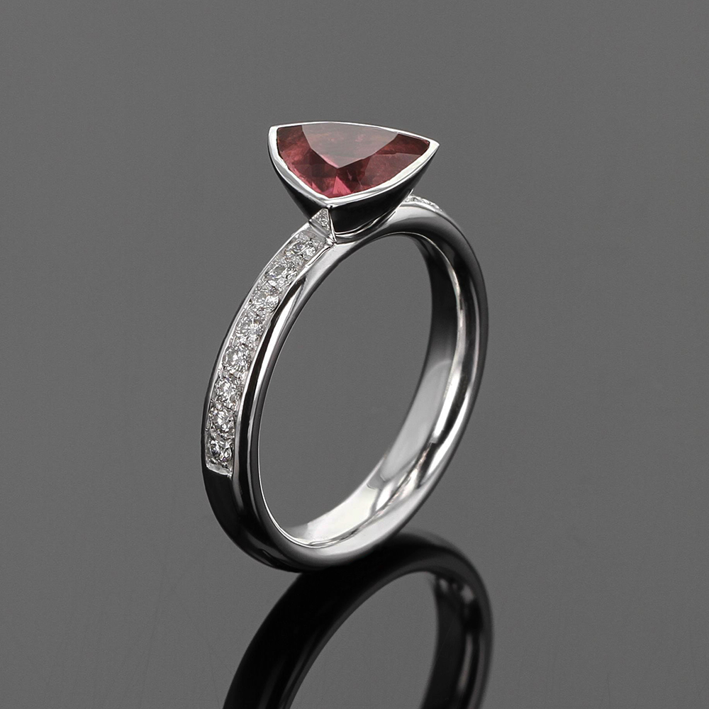 White gold ring with diamonds and a trillion shaped pink tourmaline