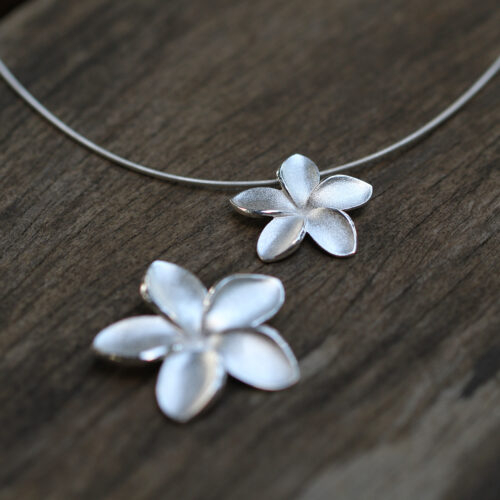 Big and small frangipani flower pendants in a brushed sterling silver