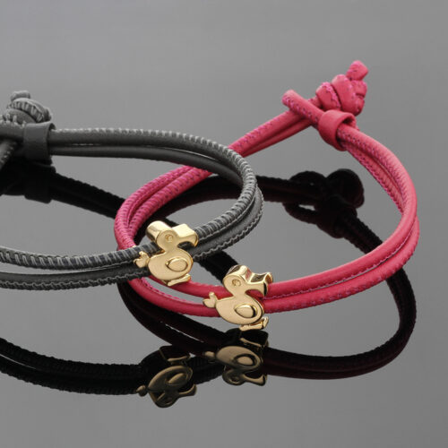 Polished rose gold dodo charms on a coral and grey coloured leather bracelets.