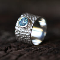 Wide silver ring with a lava rock texture and 6mm Blue Topas