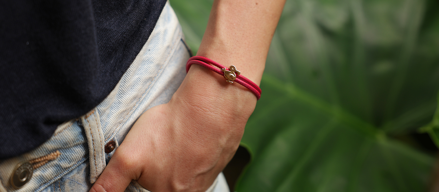 Rose gold dodo charm on a leather bracelet