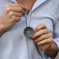 Big disc pendant in black silver with sea urchin texture and a freshwater pearl